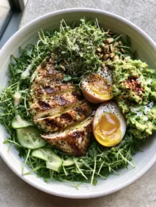 Close-up of seared lemon-herb chicken with grill marks in a white bowl. (Light dinner ideas)