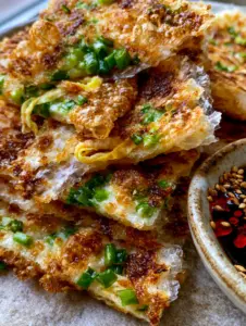 Extreme macro close-up of Rice Paper Scallion Pancakes highlighting the bubbled, translucent layers and bright green scallions.