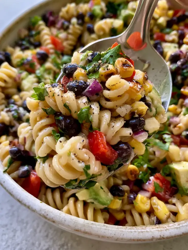 High-angle shot showing the contrast of charred corn and matte black beans in a Southwest pasta salad.