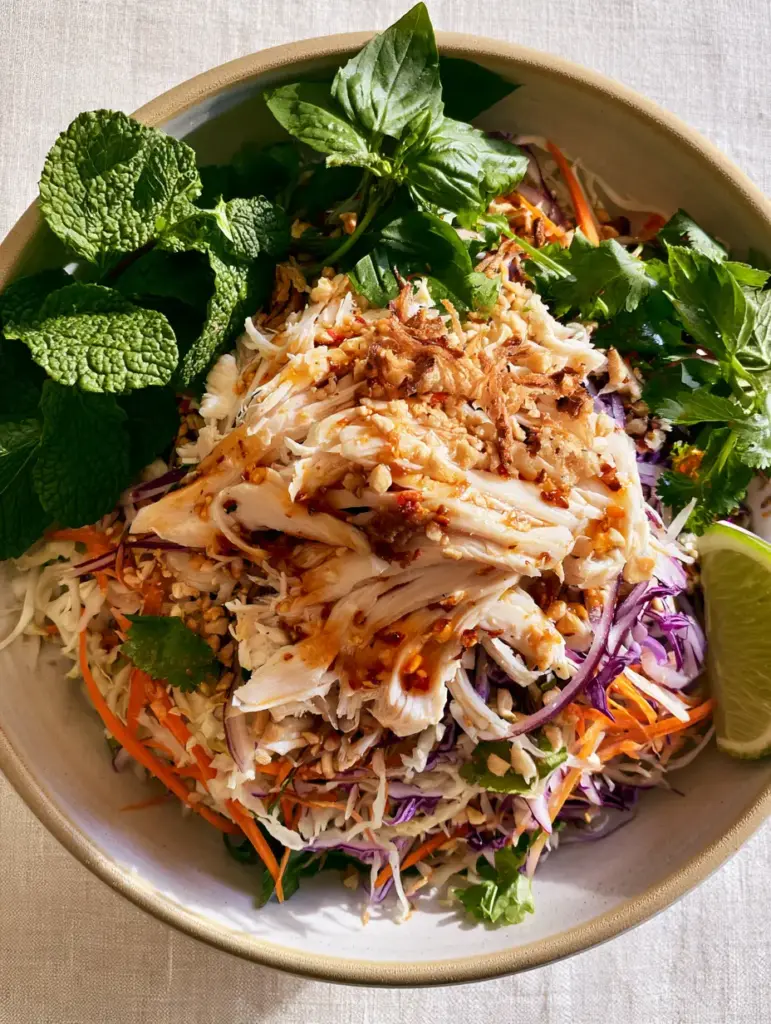 A close-up of Vietnamese Chicken Salad showing the glossy amber Nuoc Cham dressing and minced garlic flakes. (Vietnamese Chicken Salad)
