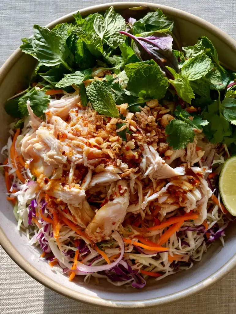 Vietnamese Chicken Salad (Goi Ga) with Zesty Nuoc Cham Dressing 1 A colorful overhead view of Goi Ga Vietnamese Chicken Salad with red cabbage, carrots, and mint leaves.