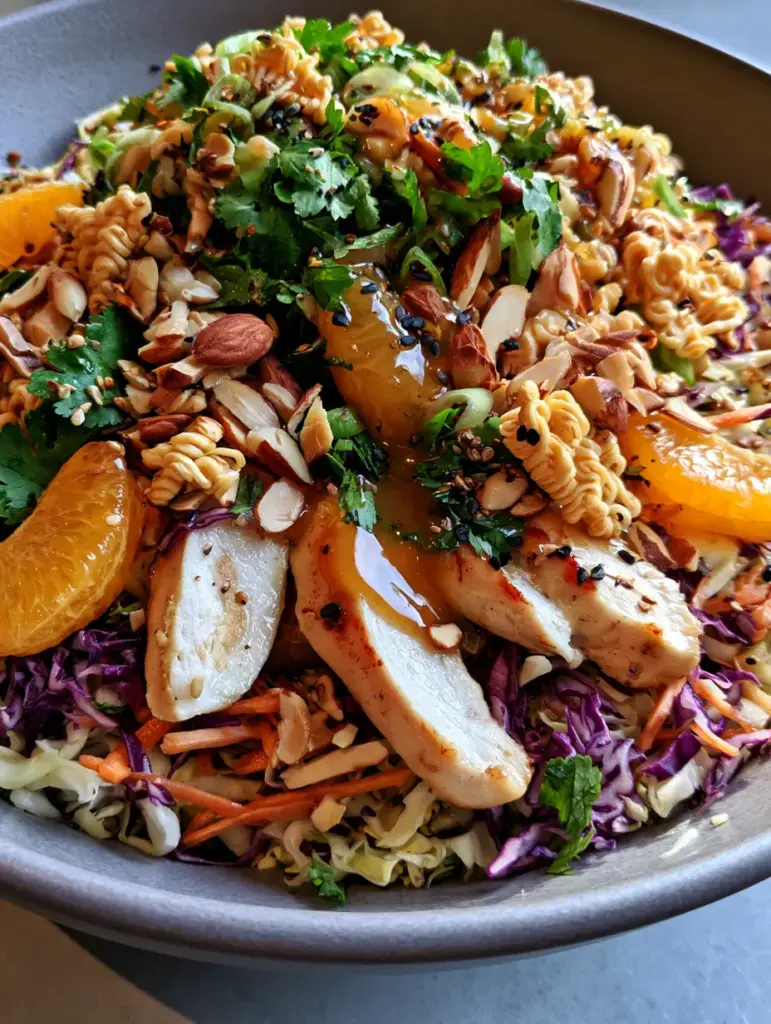 Chinese Chicken Salad with Honey-Ginger Dressing and Crispy Ramen 1 Close up of crispy fried ramen noodles and juicy mandarin oranges in a Chinese chicken salad.