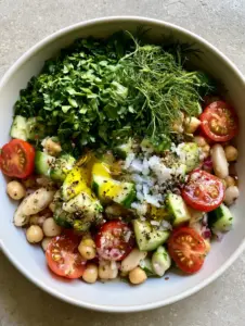 Detailed close-up of matte chickpeas and diced cucumbers in a mixed bean salad. (mixed bean salad)