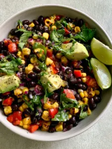 Close up of southwest bean salad showing grill marks on golden corn and red bell pepper dice.