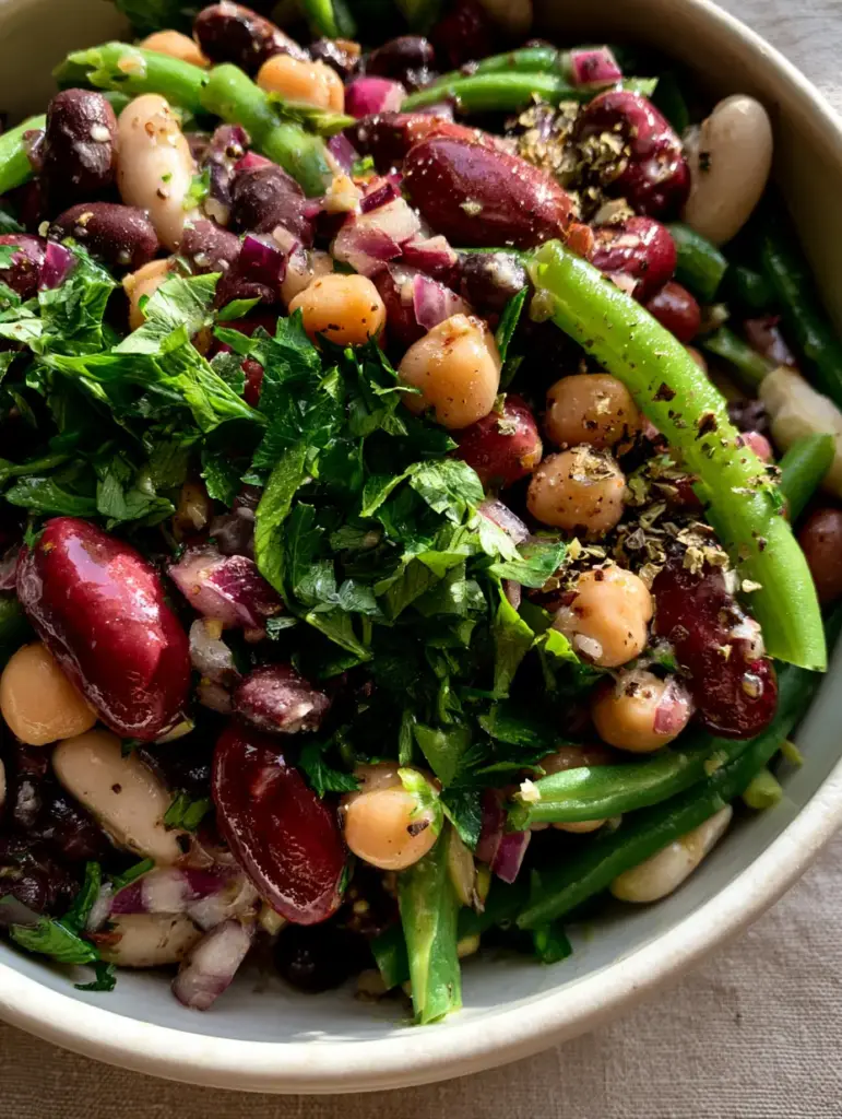 5-Bean Salad with a Shimmering Lemon-Herb Vinaigrette 1 Close-up of blanched snap beans and purple onions mixed with earthy black beans in a 5-Bean Salad.