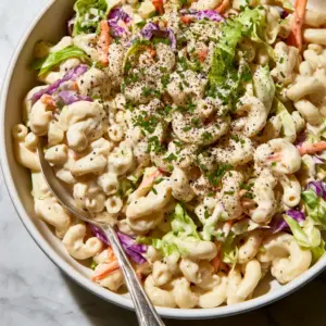 High angle shot of creamy macaroni coleslaw salad showing cabbage ribbons and carrots. (macaroni coleslaw salad)